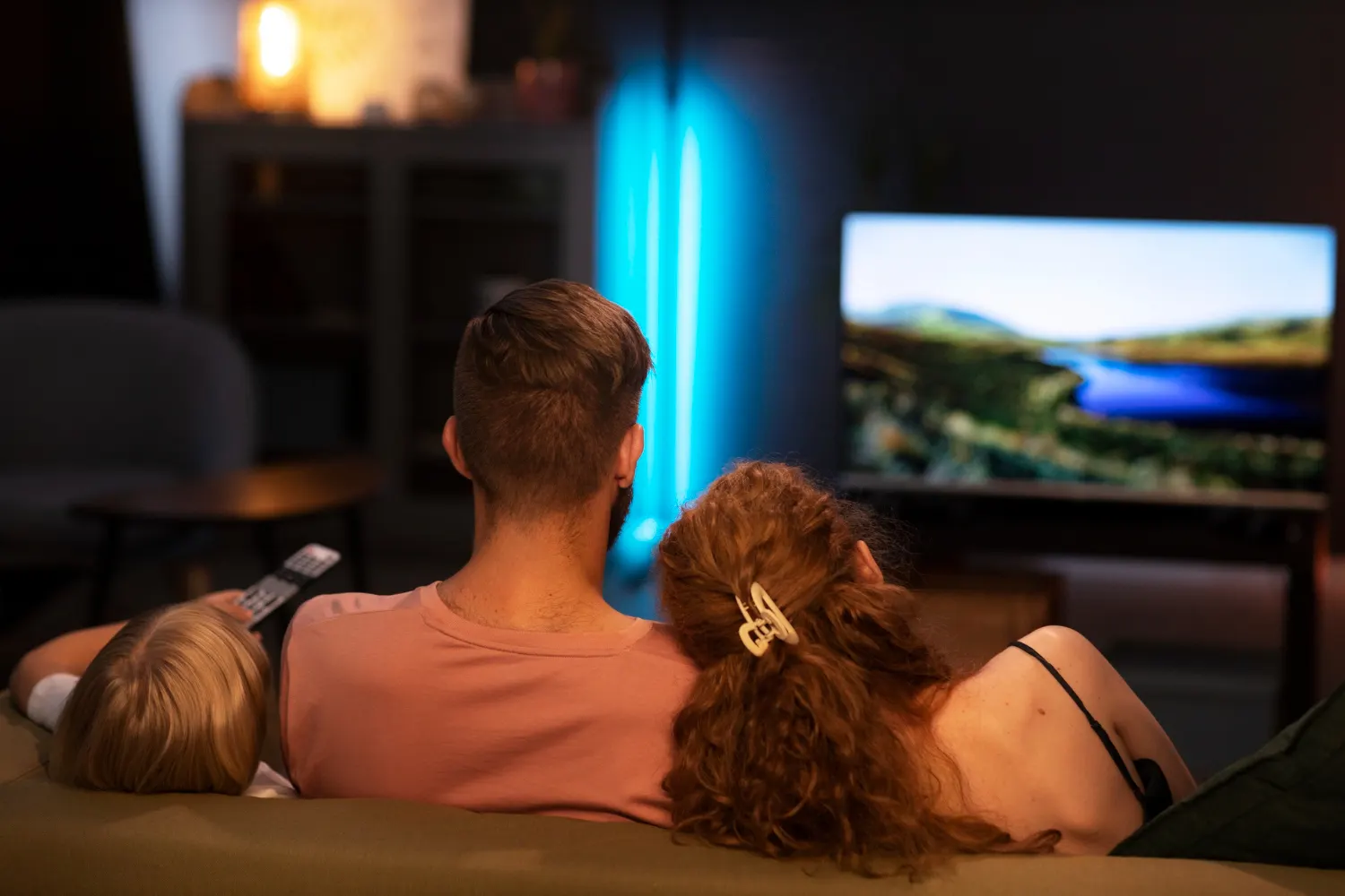 Famille regardant des chaînes en direct avec un IPTV premium sur la télévision du salon
